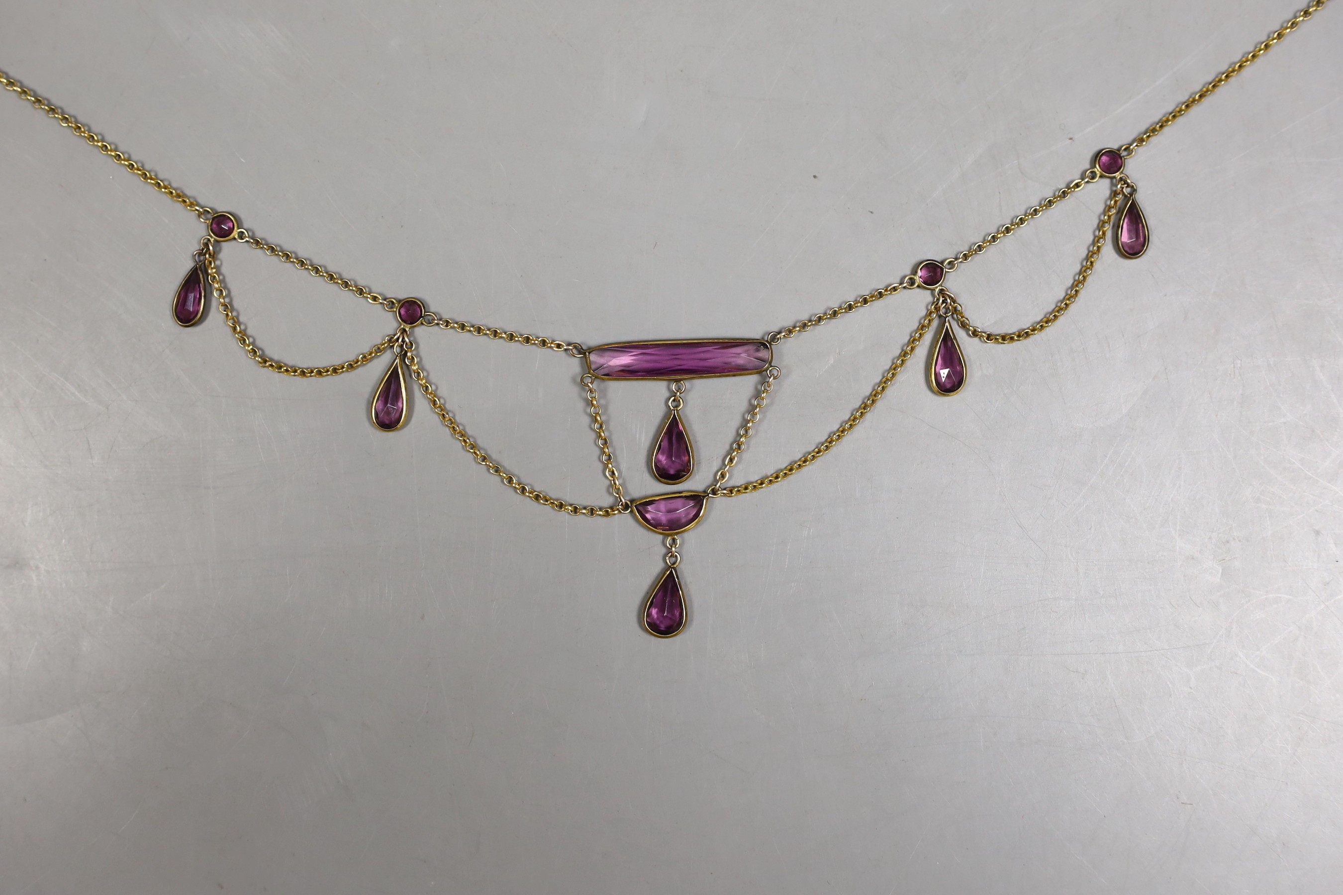 An early 20th century gilt metal and amethyst paste set drop fringe necklace, approx. 46cm.